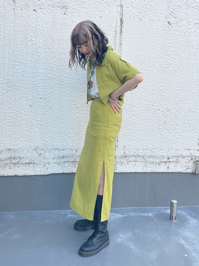 ブラック系のブーツ、グリーン系のシャツ/ブラウス、ホワイト系のTシャツ/カットソーを着用したレディースの春コーディネートの2枚目の写真