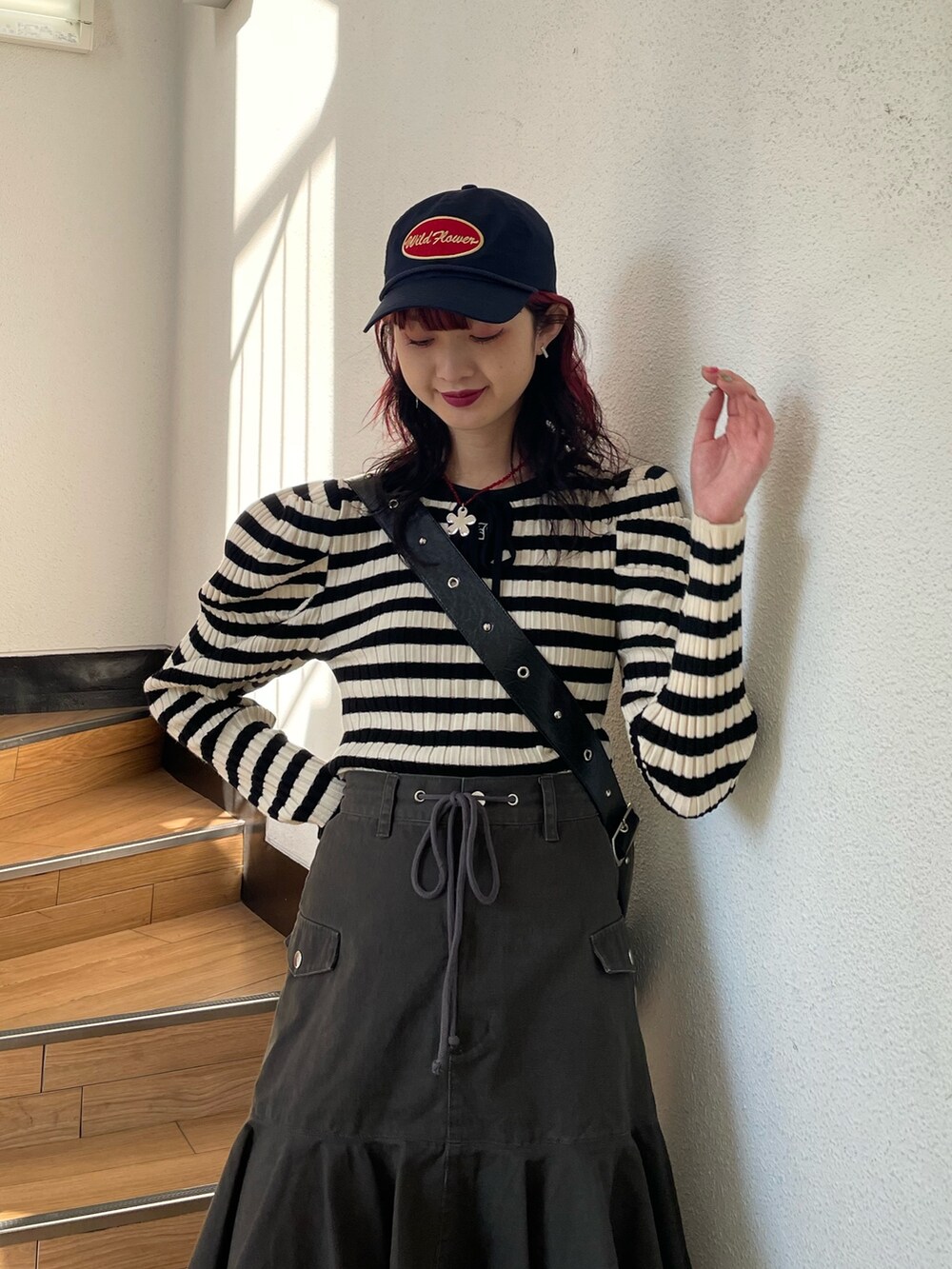 ホワイト系のニット/セーター、ブラック系のブーツ、ブラック系のスカートを着用したレディースの冬コーディネートの4枚目の写真