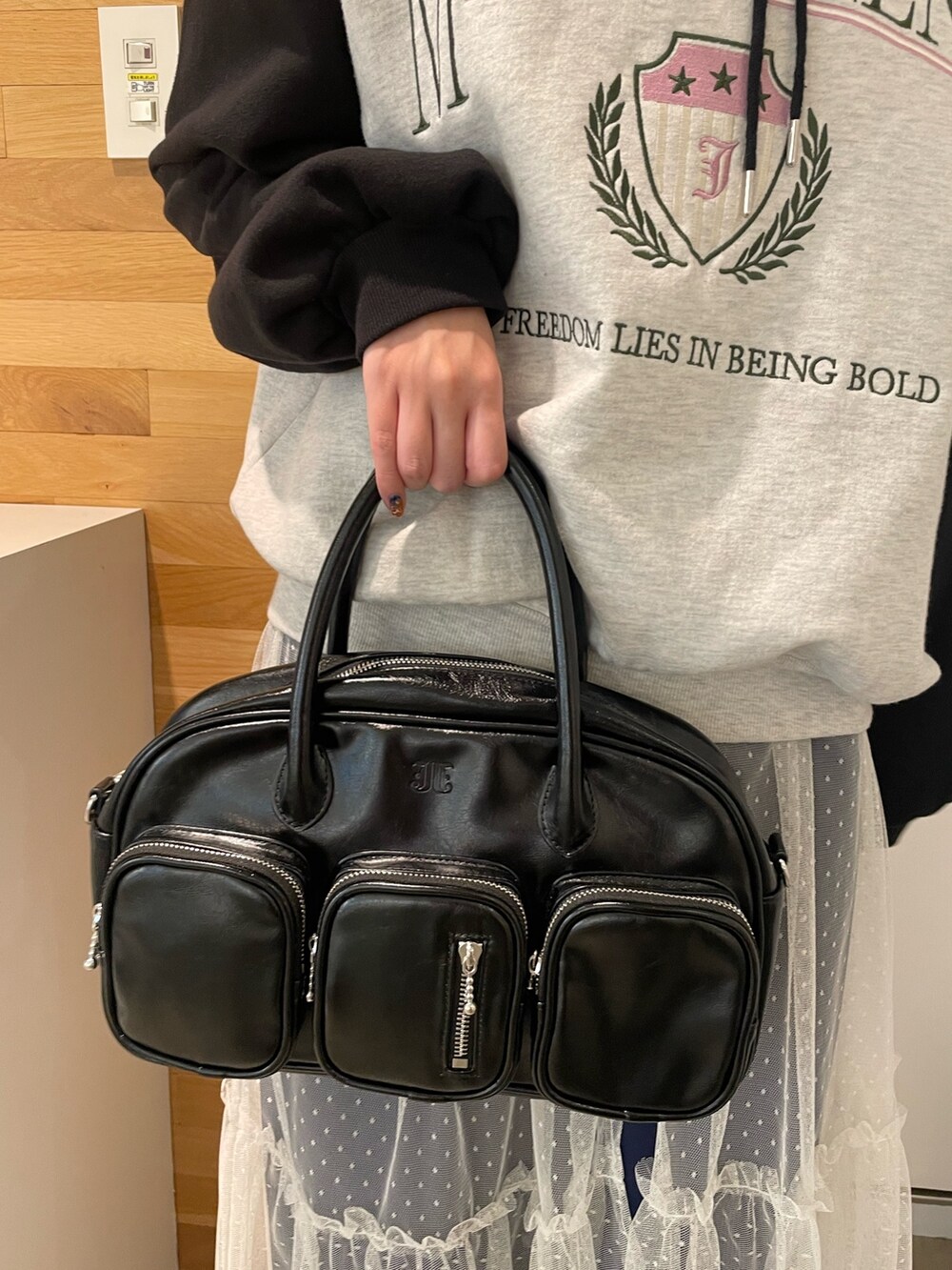 グレー系のパーカー、ホワイト系のワンピース、ブラック系のボストンバッグを着用したレディースの冬コーディネートの7枚目の写真