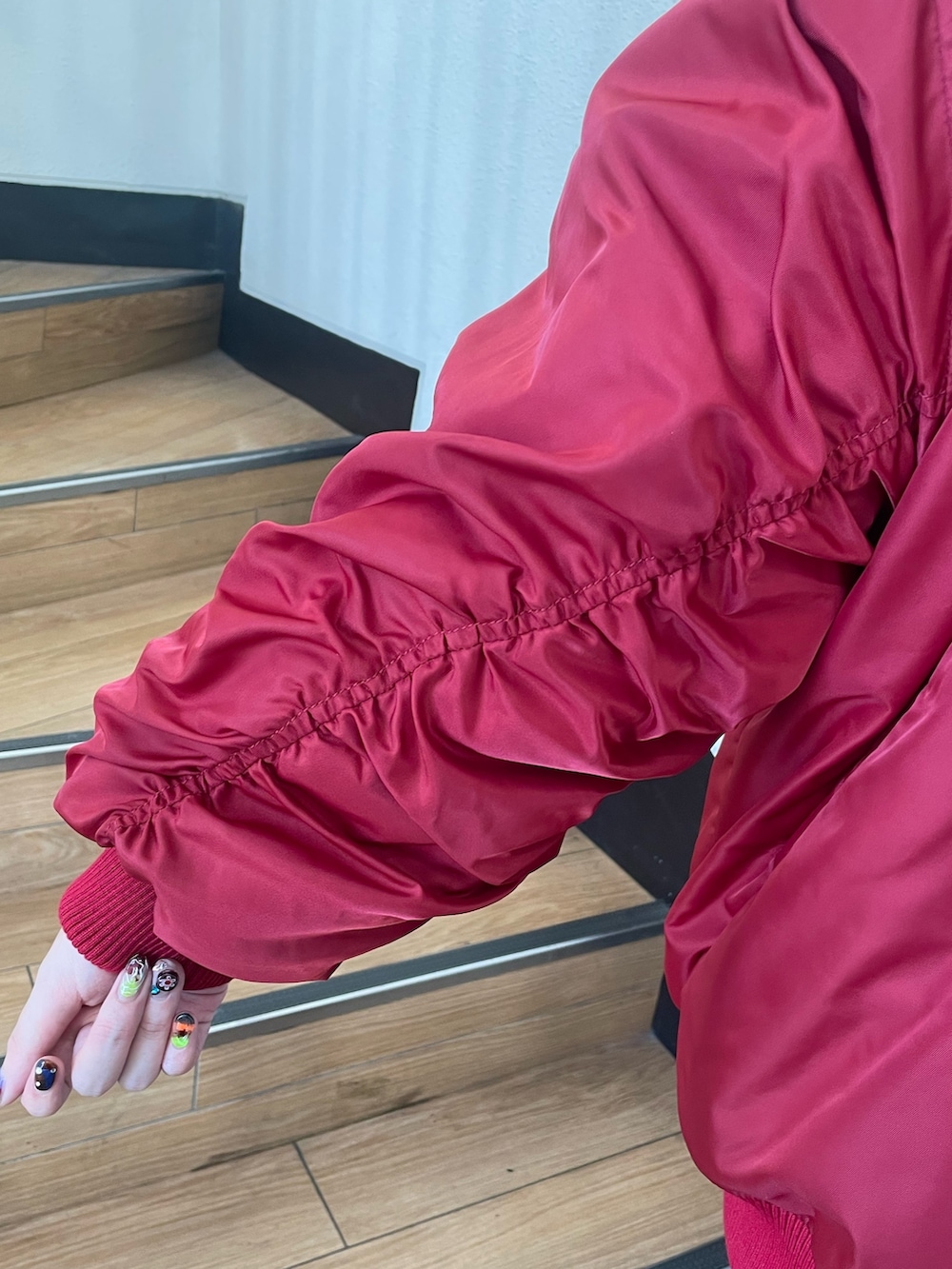 レッド系のMA-1、ホワイト系のシャツ/ブラウス、レッド系のネクタイを着用したレディースの秋コーディネートの7枚目の写真