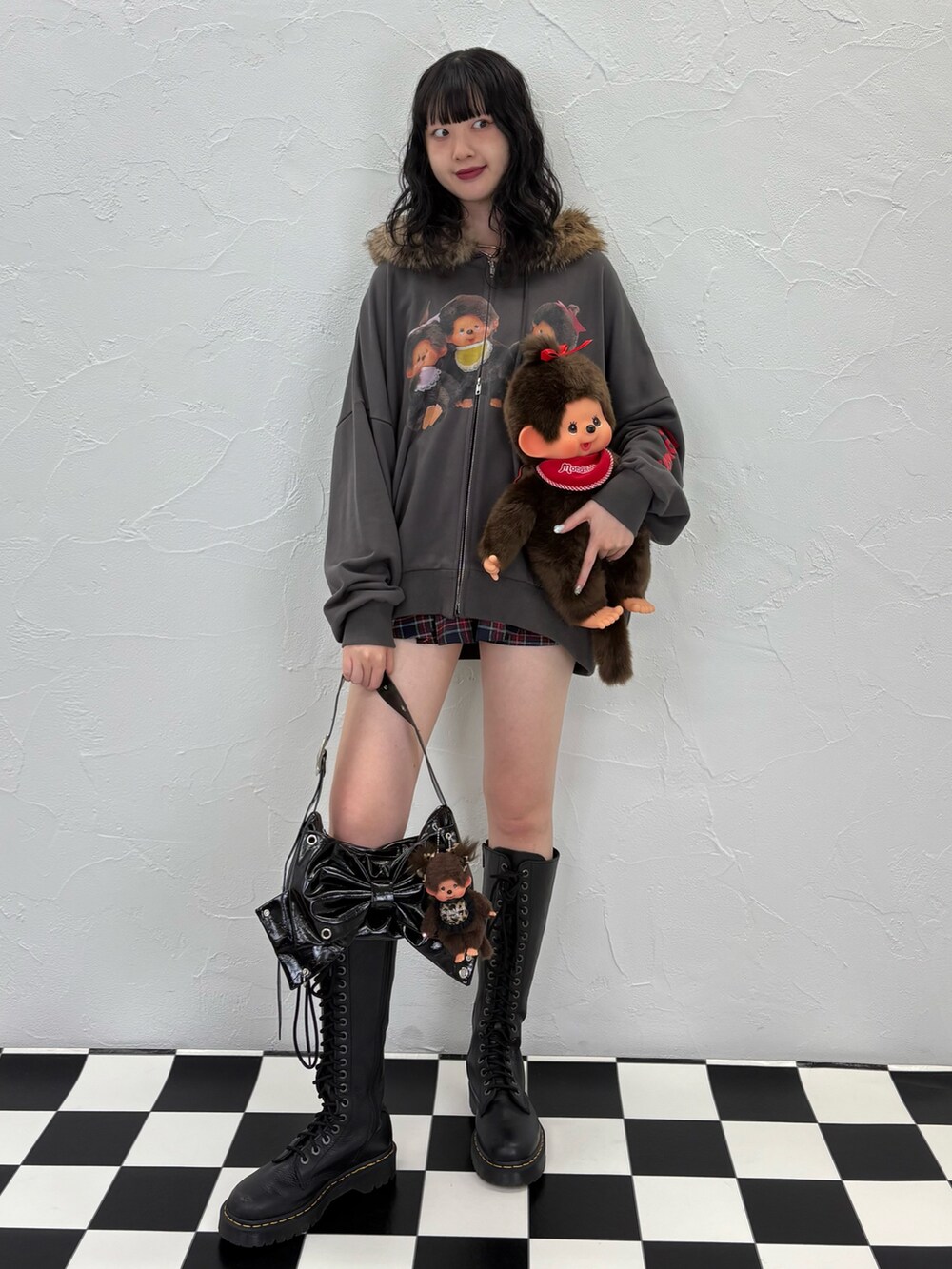 ブラック系のパーカー、ブルー系のスカート、ブラック系のショルダーバッグを着用したレディースの夏コーディネートの2枚目の写真