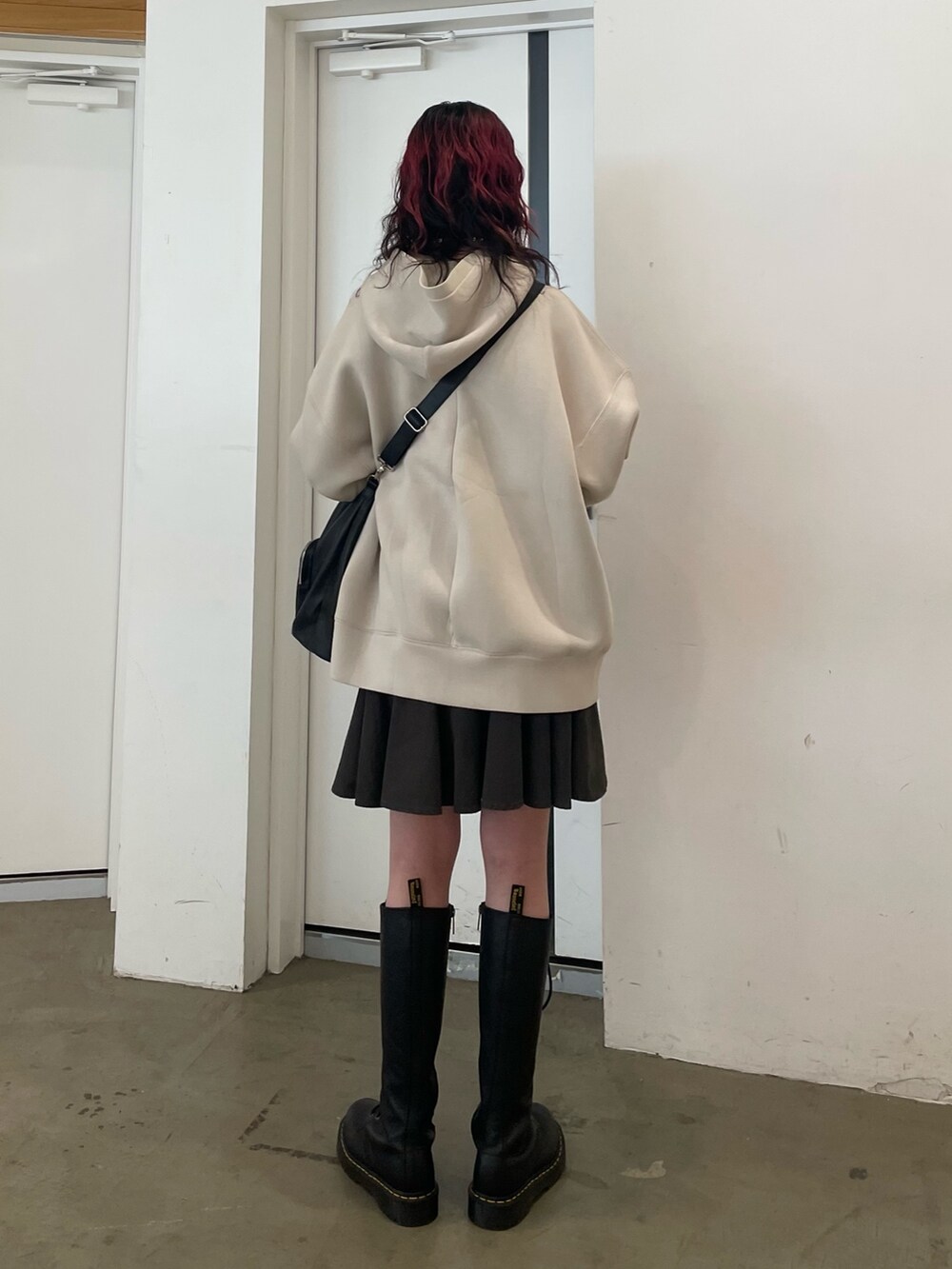 ホワイト系のパーカー、ブラック系のバックパック/リュック、ブラック系のスカートを着用したレディースの冬コーディネートの3枚目の写真