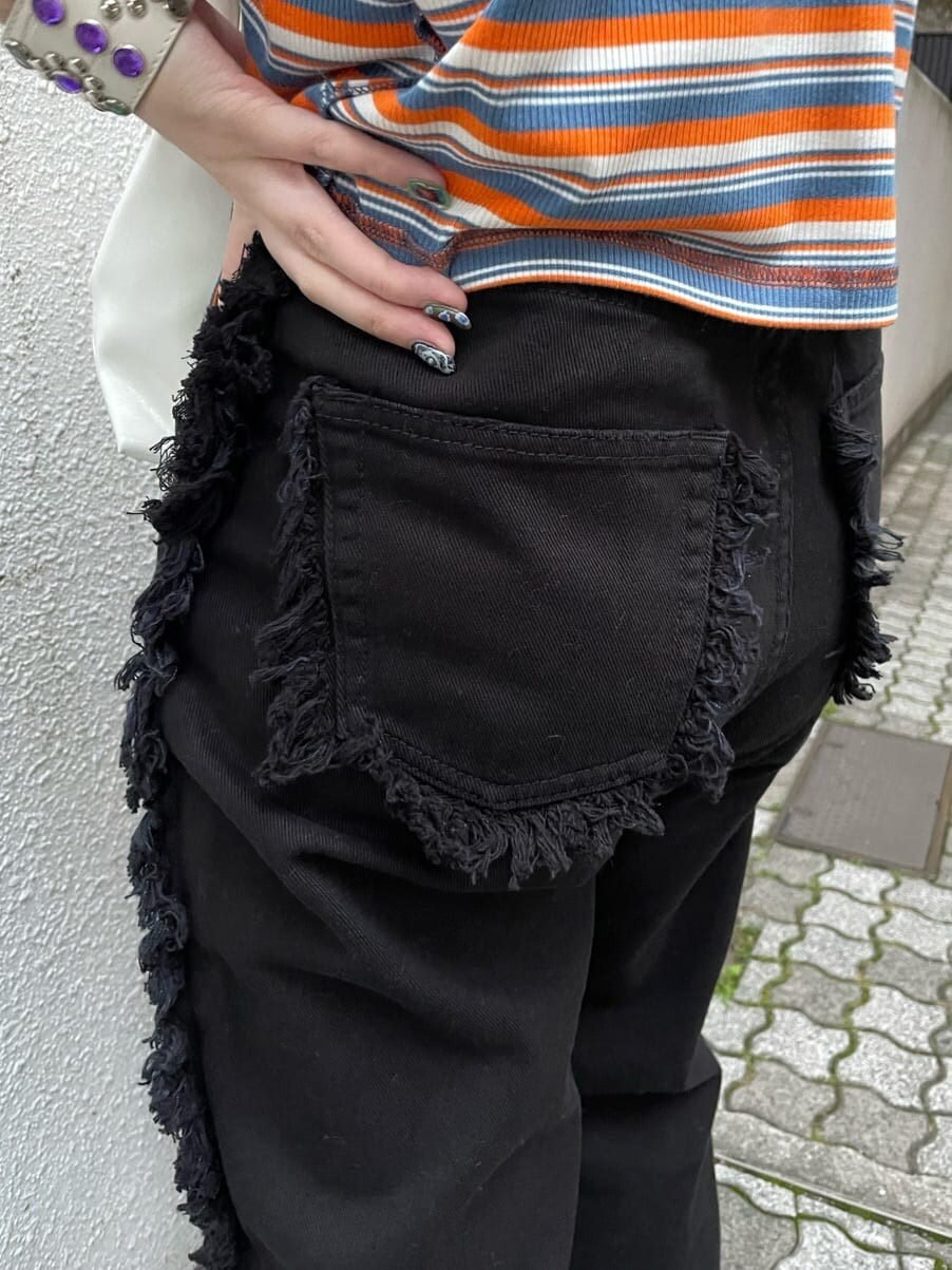 ブラック系のブーツ、ホワイト系のハンドバッグ、ブラック系のデニムパンツを着用したレディースの夏コーディネートの7枚目の写真