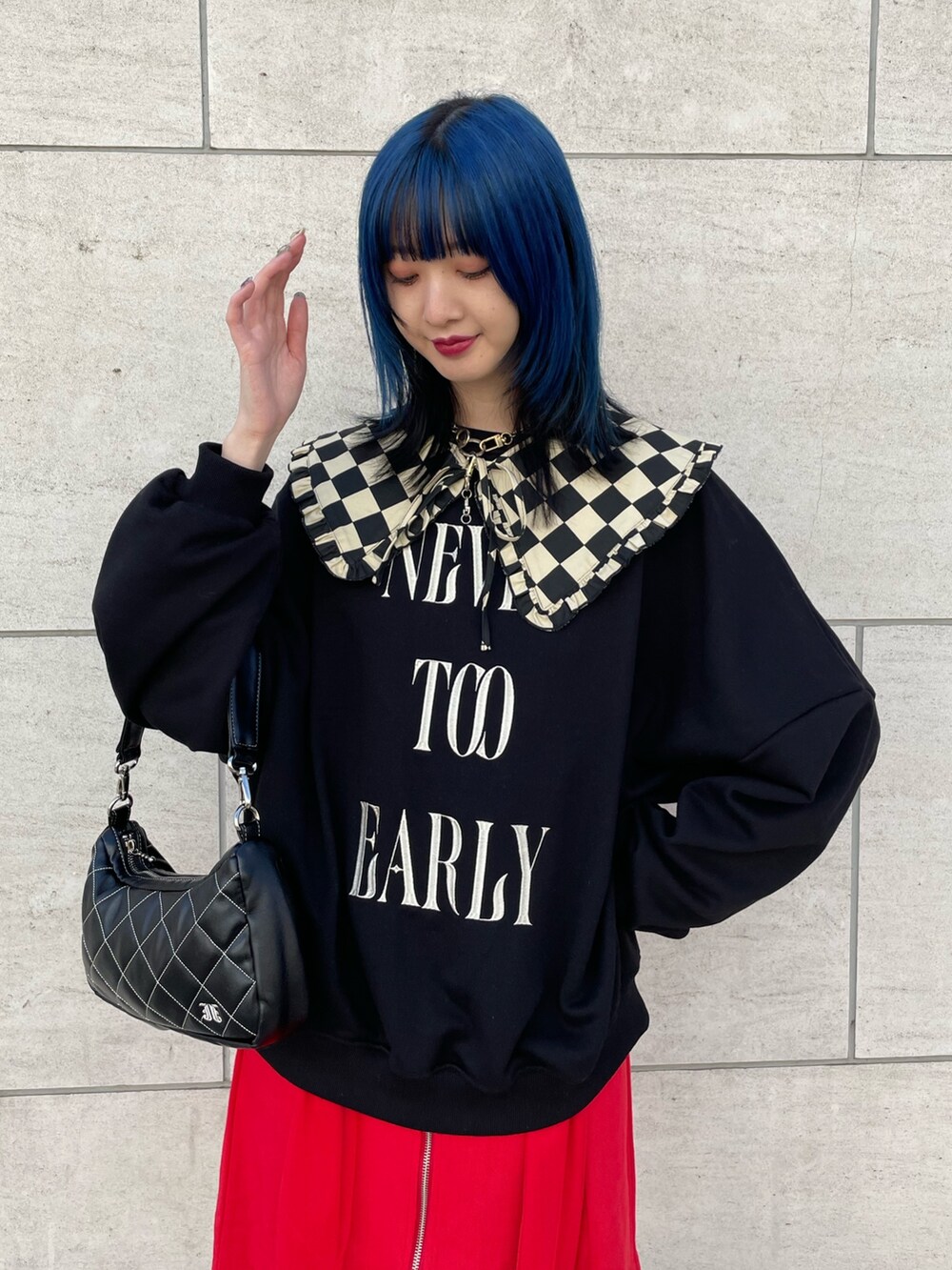 ブラック系のスウェット、レッド系のジャンパースカート、ブラック系のブーツを着用したレディースの冬コーディネートの4枚目の写真