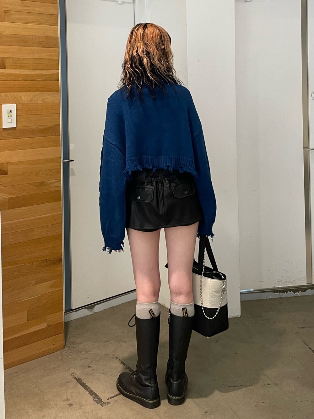 ブラック系のその他パンツ、ブルー系のニット/セーター、ブラック系のブーツを着用したレディースの冬コーディネートの3枚目の写真