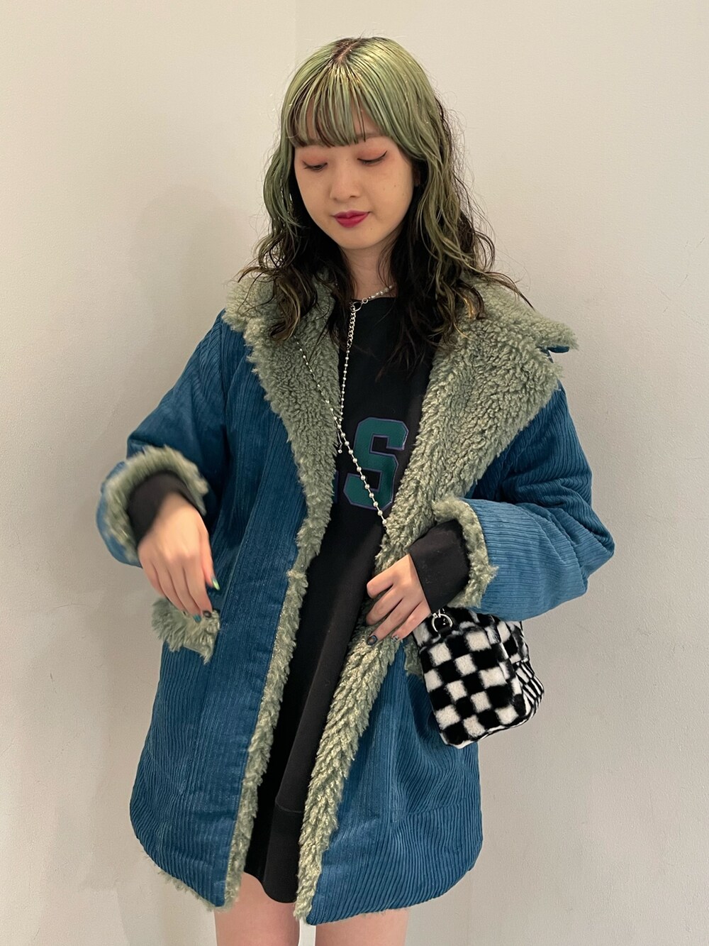 ブラック系のスウェット、ブラック系のボストンバッグ、ブラック系のブーツを着用したレディースの秋コーディネートの4枚目の写真