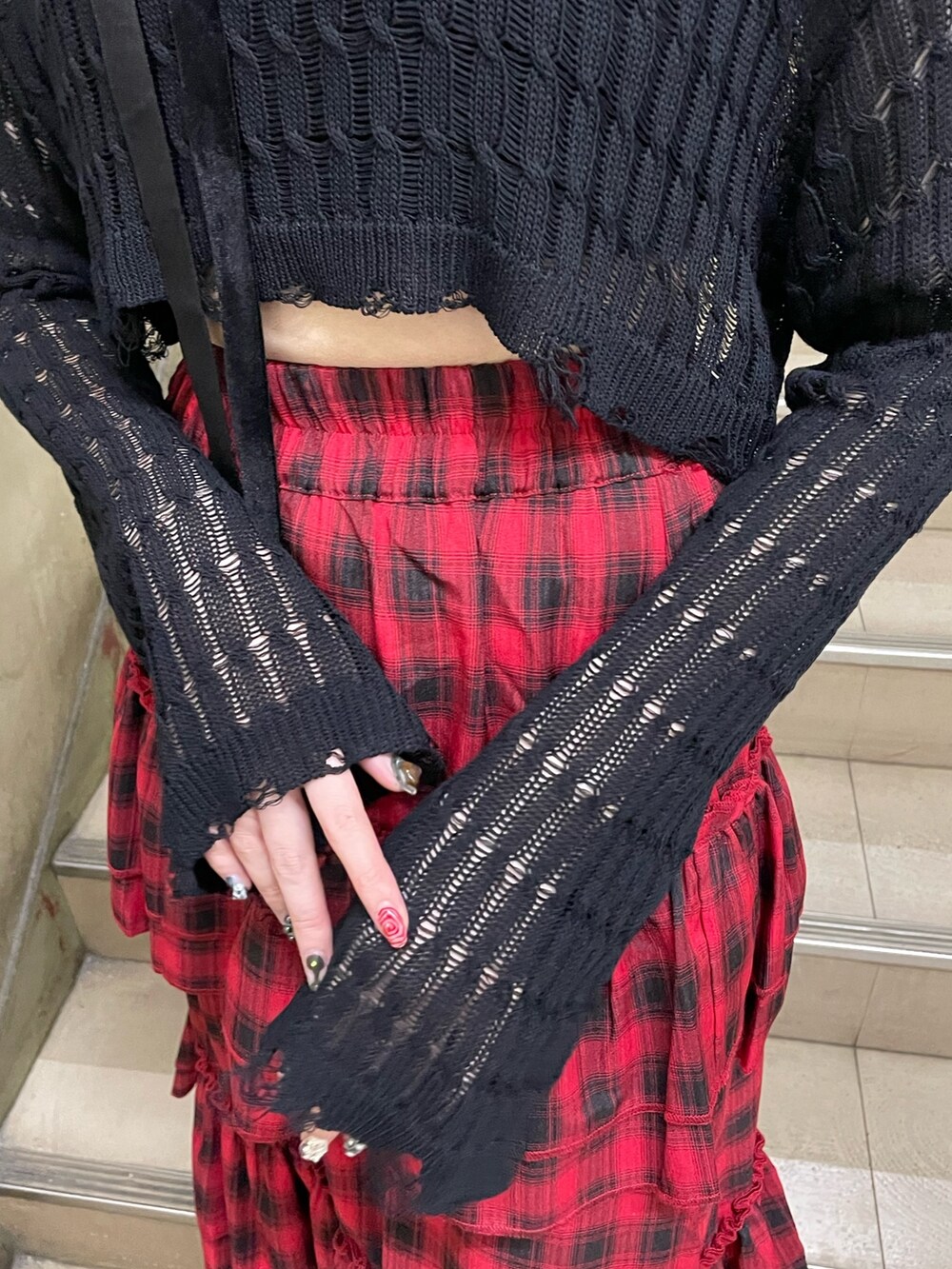 ブラック系のニット/セーター、ブラック系のタンクトップ、レッド系のスカートを着用したレディースの春コーディネートの6枚目の写真