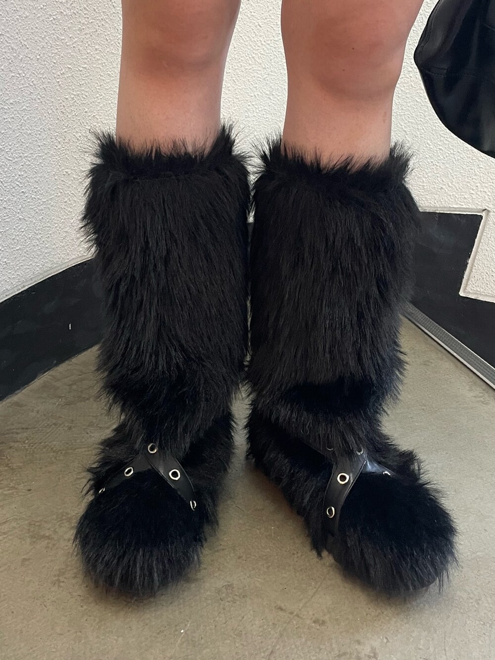 ブラック系のニット/セーター、ホワイト系のタンクトップ、ブラック系のデニムパンツを着用したレディースの秋コーディネートの8枚目の写真