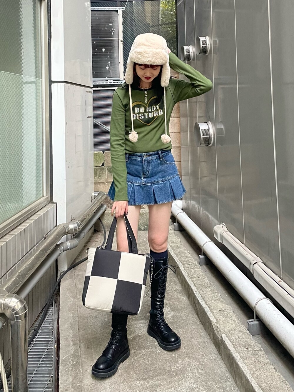 ブルー系のデニムパンツ、グリーン系のTシャツ/カットソー、ホワイト系のトートバッグを着用したレディースの秋コーディネートの2枚目の写真