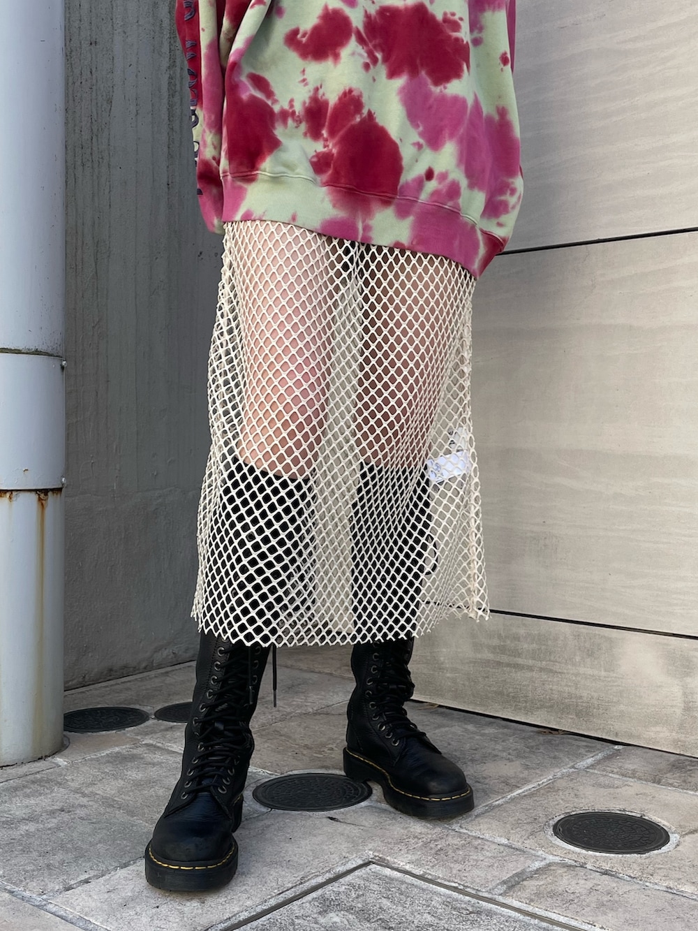 グリーン系のスウェット、ホワイト系のワンピース、ブラック系のブーツを着用したレディースの冬コーディネートの8枚目の写真