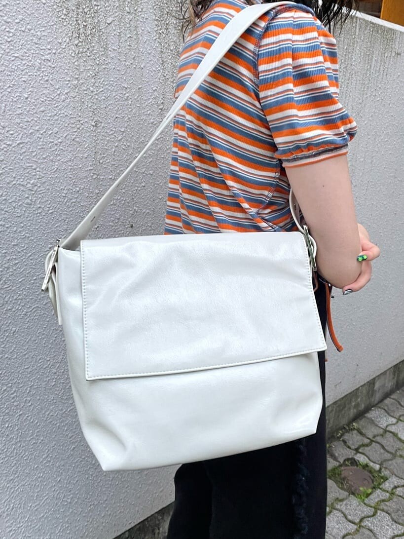 ブラック系のブーツ、ホワイト系のハンドバッグ、ブラック系のデニムパンツを着用したレディースの夏コーディネートの8枚目の写真