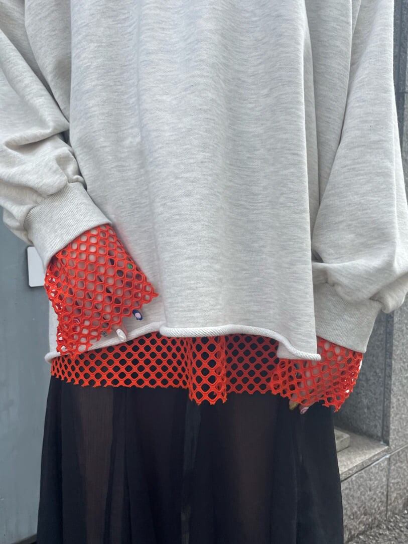 ブラック系のブーツ、ブラック系のスカート、オレンジ系のTシャツ/カットソーを着用したレディースの春コーディネートの7枚目の写真