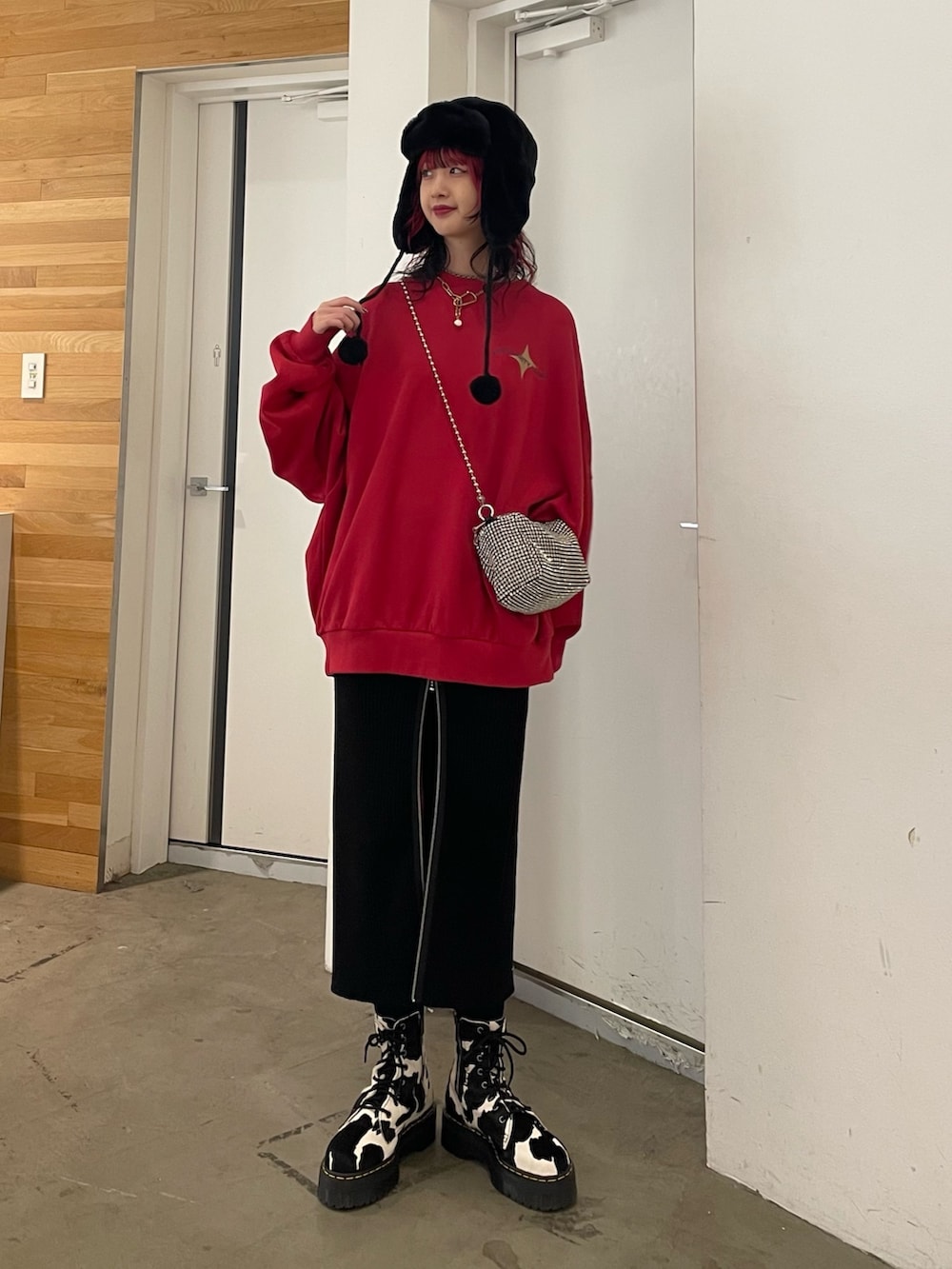 ブラック系のスカート、ブラック系のブーツ、レッド系のTシャツ/カットソーを着用したレディースの秋コーディネートの2枚目の写真