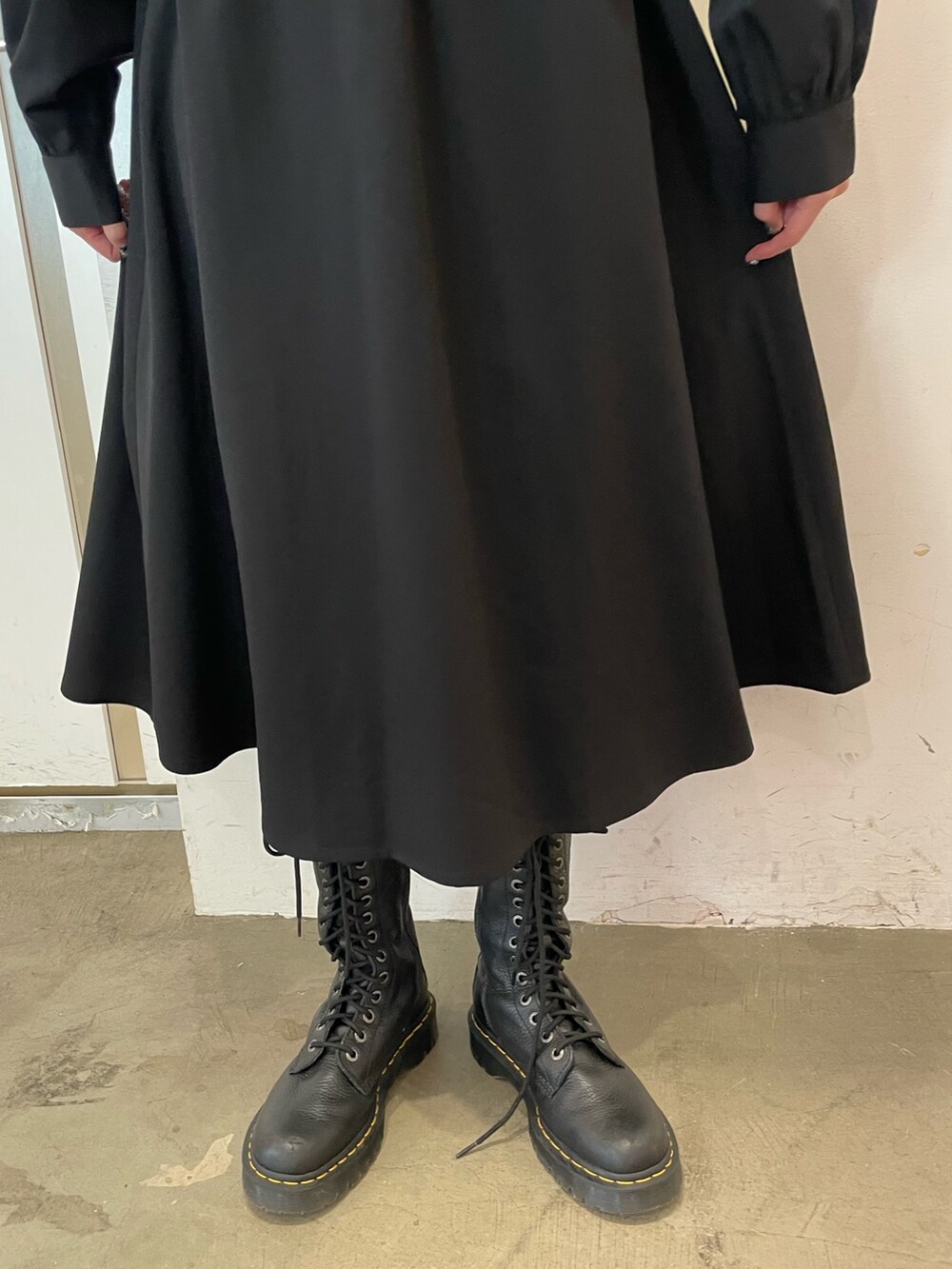 ホワイト系のショルダーバッグ、ブラック系のワンピース、ブラック系のブーツを着用したレディースの冬コーディネートの7枚目の写真