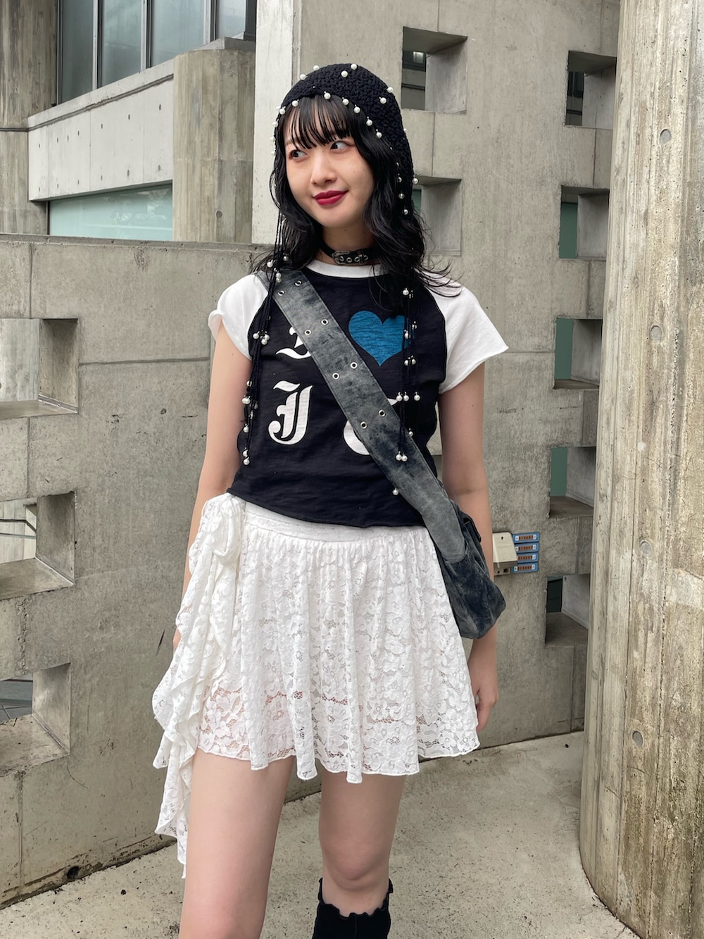 ブラック系のTシャツ/カットソー、ブラック系のメッセンジャーバッグ、ホワイト系のスカートを着用したレディースの春コーディネートの4枚目の写真