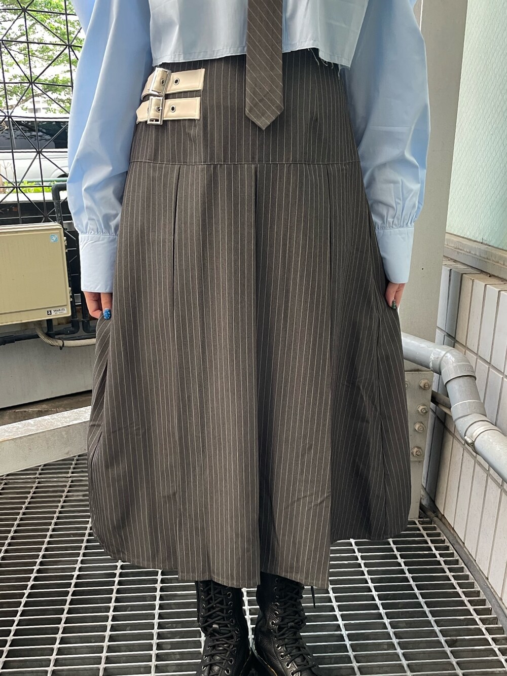 グレー系のスカート、ブルー系のシャツ/ブラウス、ブラック系のブーツを着用したレディースの春コーディネートの9枚目の写真