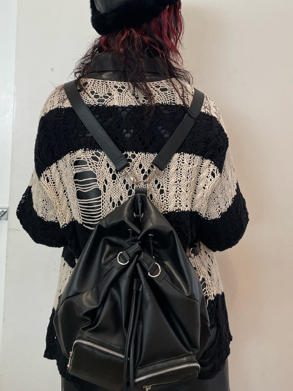 ブラック系のニット/セーター、その他のワンピース、ブラック系のブーツを着用したレディースの冬コーディネートの7枚目の写真