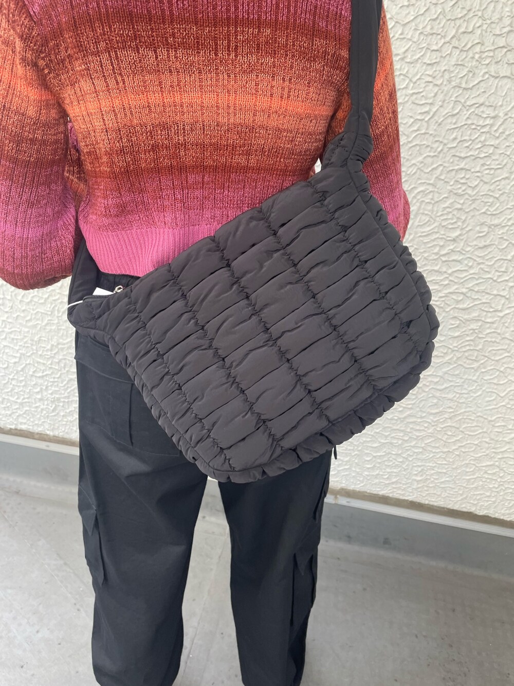 ブラック系のカーゴパンツ、ブラック系のハンドバッグ、ピンク系のカーディガン/ボレロを着用したレディースの秋コーディネートの6枚目の写真