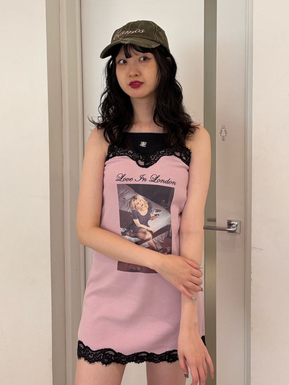 ピンク系のワンピース、ブラック系のパンプス、グリーン系のキャップを着用したレディースの夏コーディネートの4枚目の写真