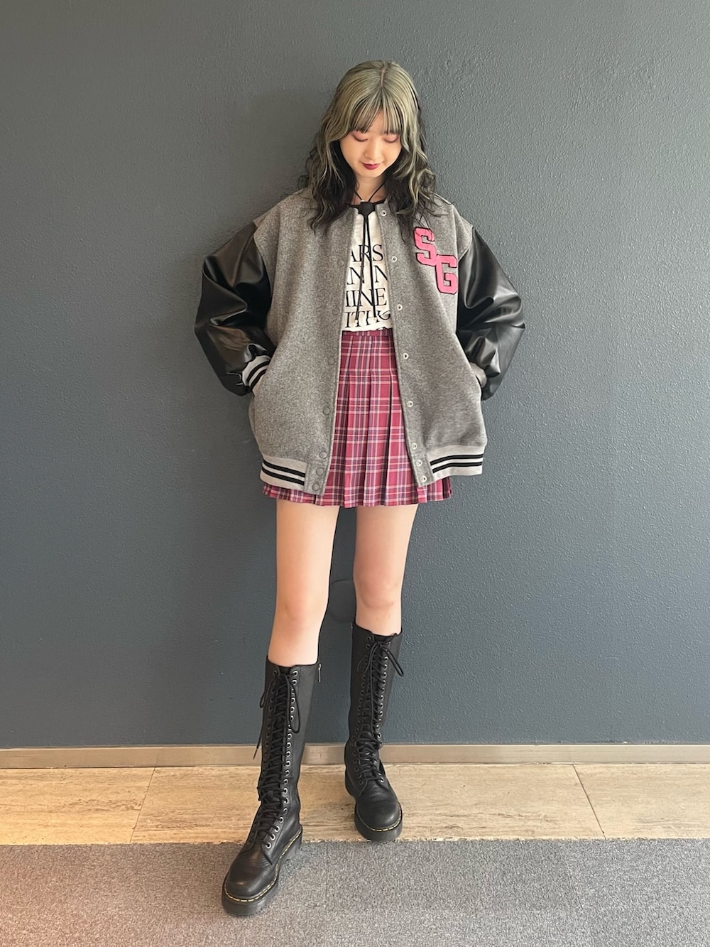 ピンク系のスカート、グレー系のスタジャン、ホワイト系のTシャツ/カットソーを着用したレディースの秋コーディネートの2枚目の写真