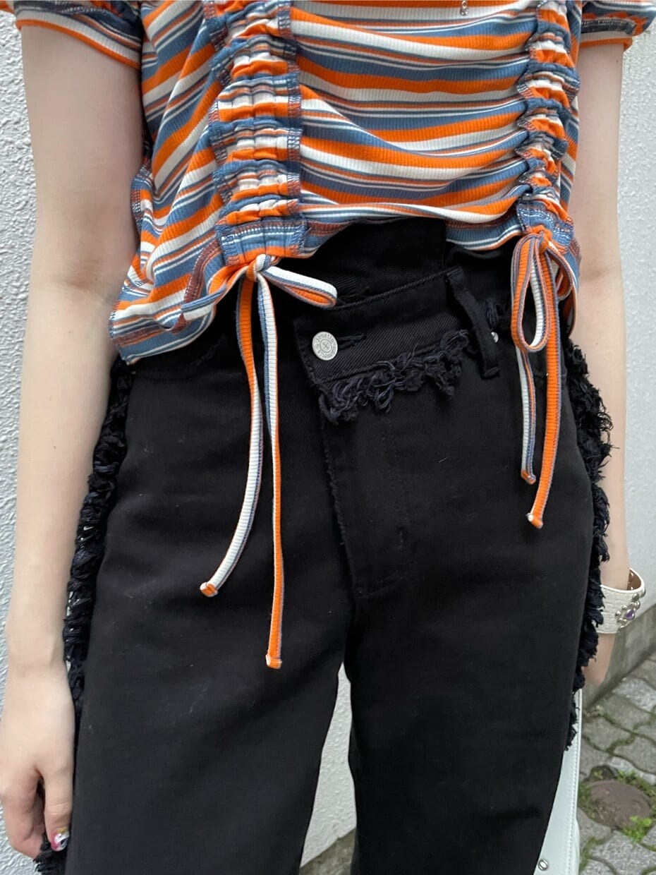 ブラック系のブーツ、ホワイト系のハンドバッグ、ブラック系のデニムパンツを着用したレディースの夏コーディネートの5枚目の写真