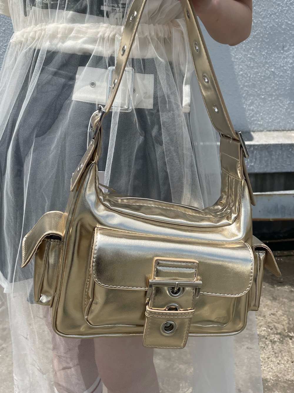 ホワイト系のワンピース、グレー系のスカート、ゴールド系のハンドバッグを着用したレディースの夏コーディネートの9枚目の写真