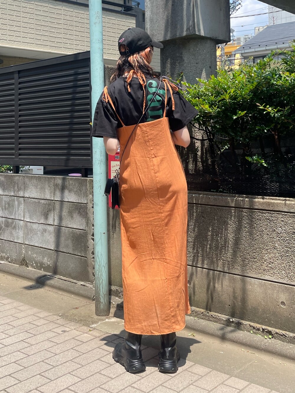 ブラック系のTシャツ/カットソー、オレンジ系のワンピース、ブラック系のショルダーバッグを着用したレディースの夏コーディネートの3枚目の写真