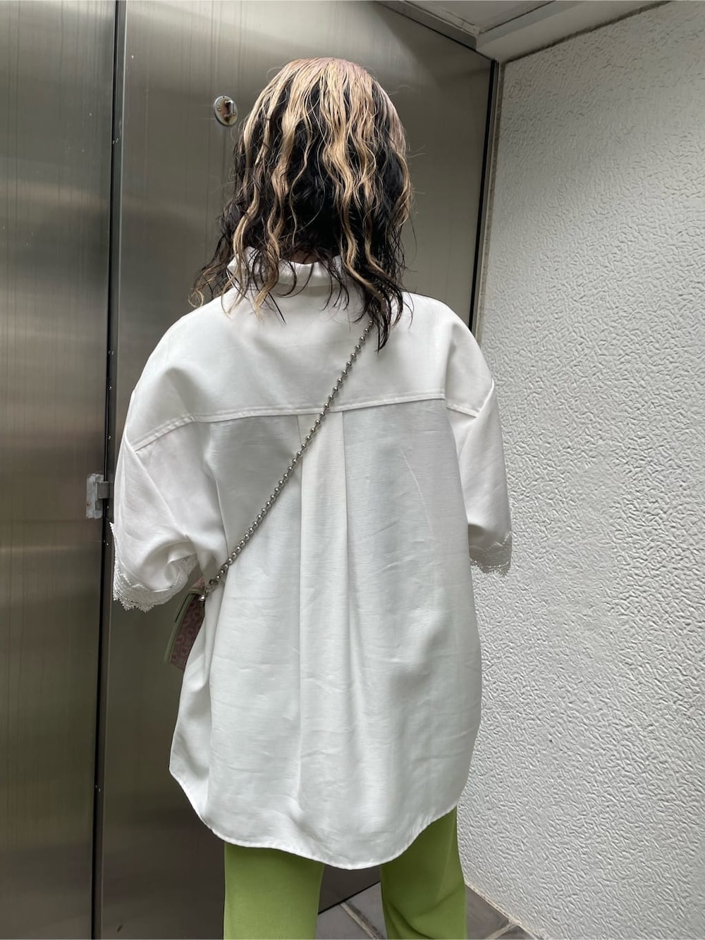 ピンク系のハンドバッグ、グリーン系のその他パンツ、オレンジ系のシャツ/ブラウスを着用したレディースの夏コーディネートの5枚目の写真