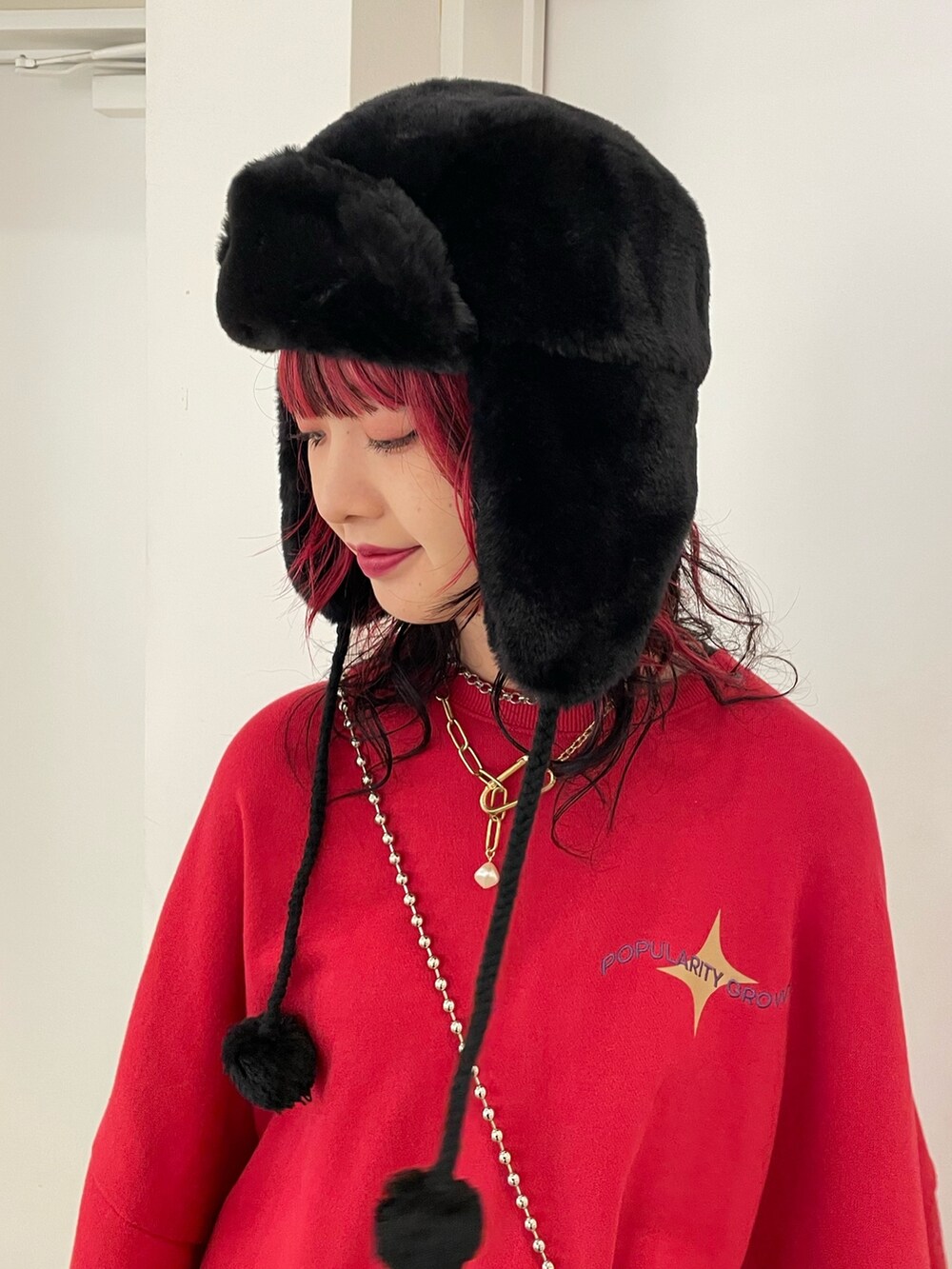 ブラック系のスカート、ブラック系のブーツ、レッド系のTシャツ/カットソーを着用したレディースの秋コーディネートの9枚目の写真