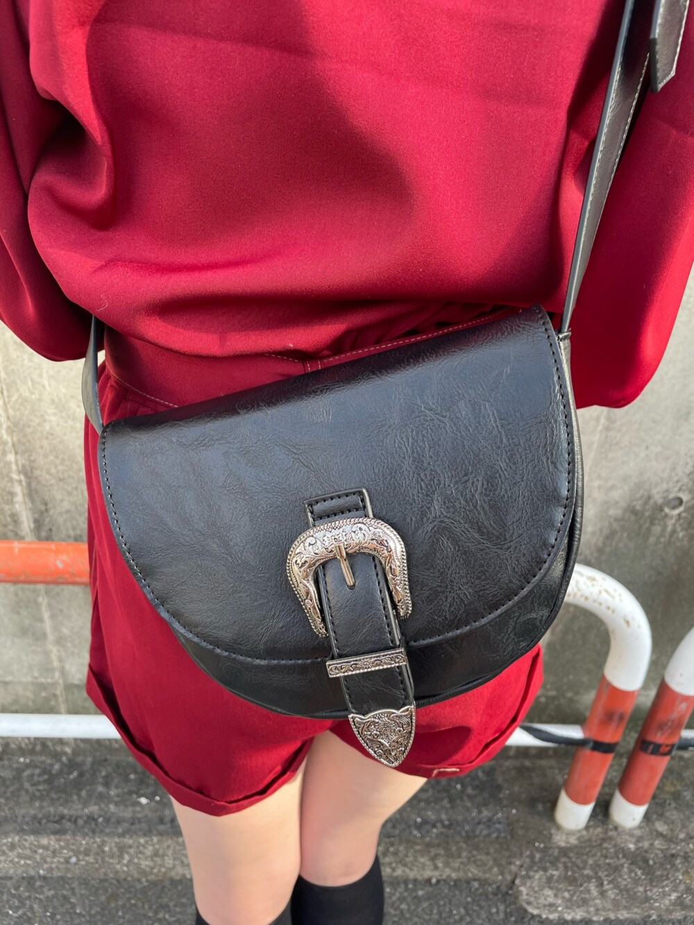 ブラック系のサンダル、レッド系のつなぎ/オールインワン、ブラック系のショルダーバッグを着用したレディースの春コーディネートの9枚目の写真