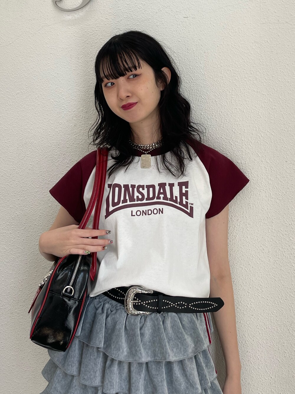 ホワイト系のTシャツ/カットソー、グレー系のスカート、ブラック系のボストンバッグを着用したレディースの春コーディネートの4枚目の写真