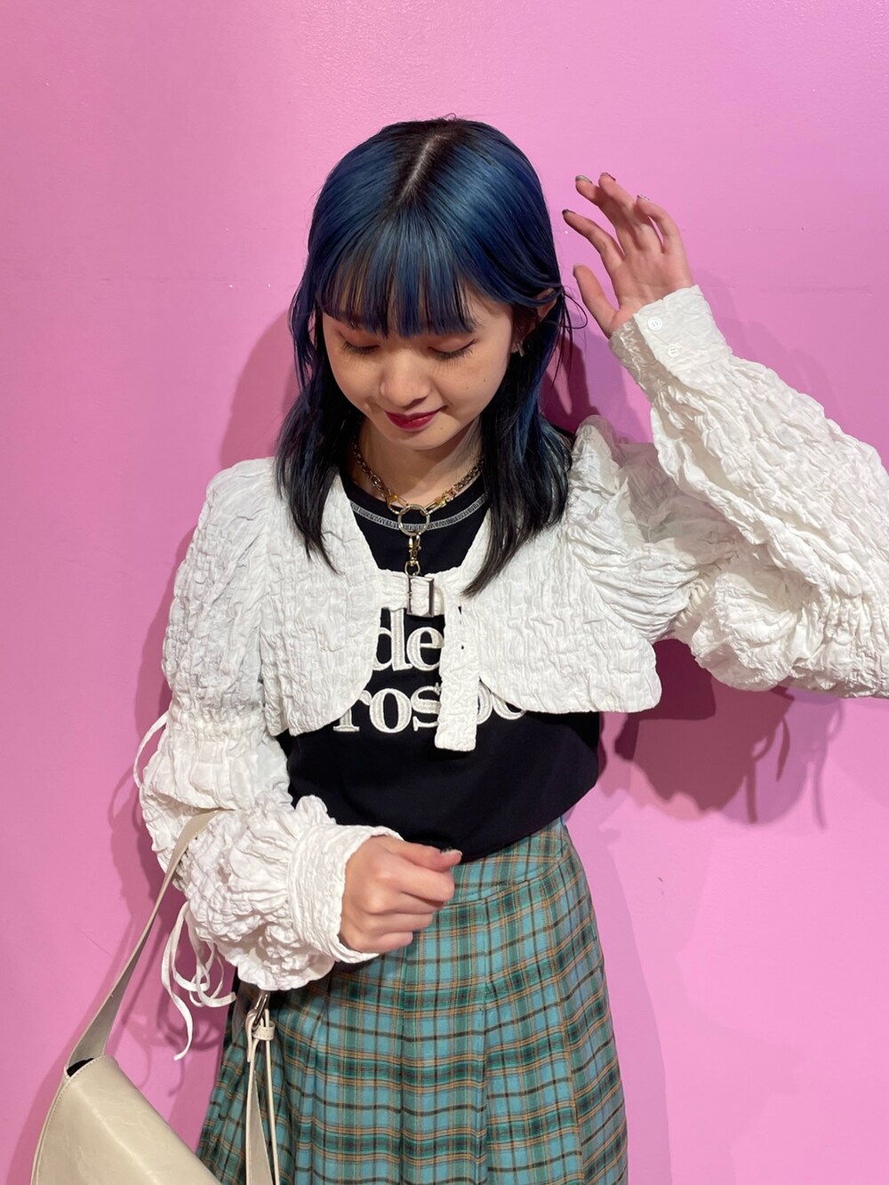 ブラック系のTシャツ/カットソー、ホワイト系のカーディガン/ボレロ、グリーン系のスカートを着用したレディースの冬コーディネートの4枚目の写真