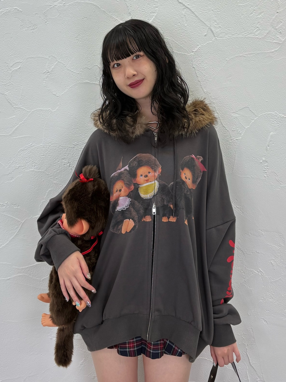 ブラック系のパーカー、ブルー系のスカート、ブラック系のショルダーバッグを着用したレディースの夏コーディネートの3枚目の写真