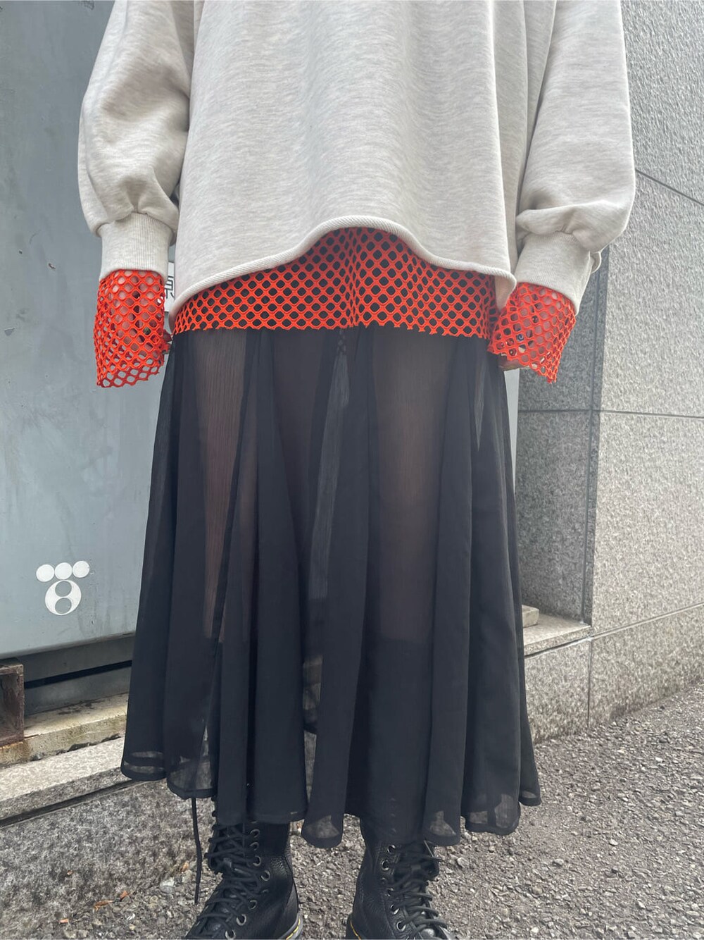 ブラック系のブーツ、ブラック系のスカート、オレンジ系のTシャツ/カットソーを着用したレディースの春コーディネートの8枚目の写真