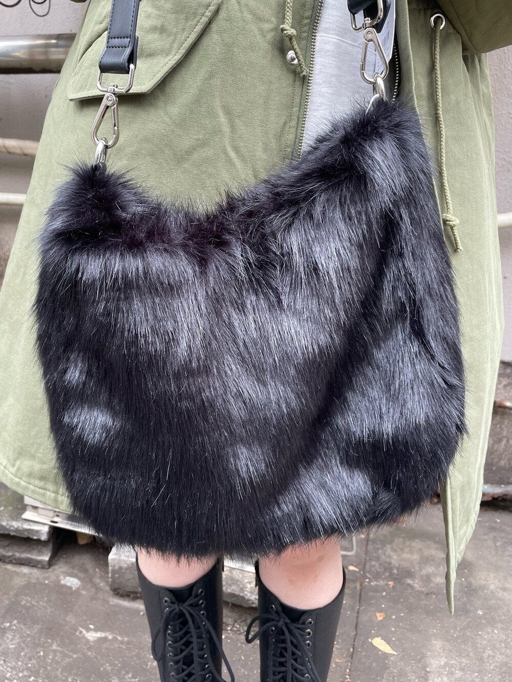 グリーン系のモッズコート、ブラック系のスカート、ブラック系のブーツを着用したレディースの秋コーディネートの9枚目の写真