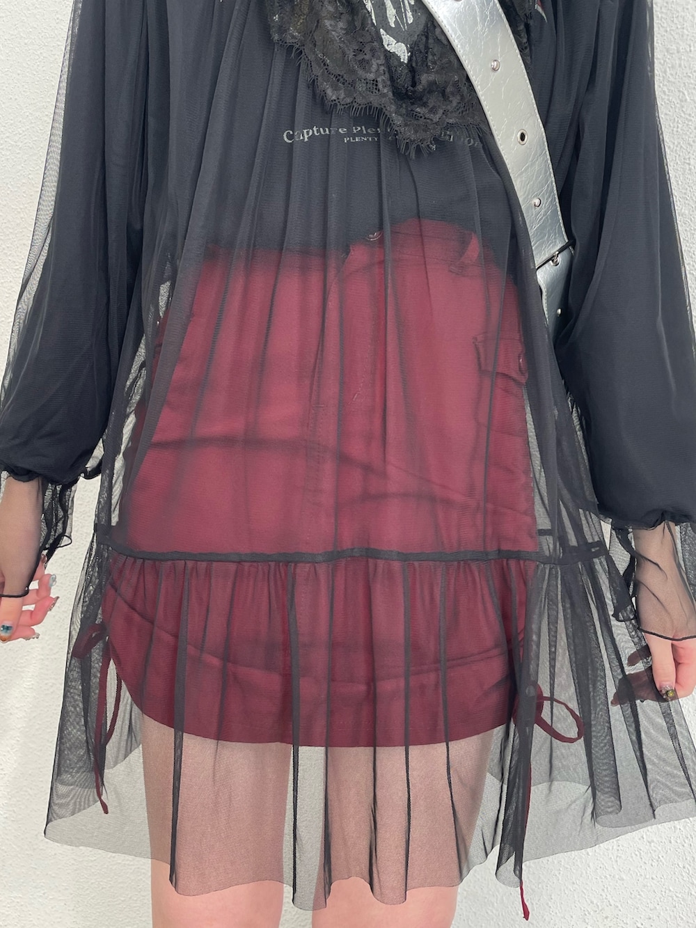 ブラック系のワンピース、レッド系のスカート、シルバー系のショルダーバッグを着用したレディースの冬コーディネートの6枚目の写真