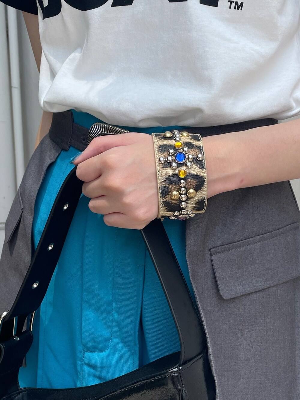 ホワイト系のTシャツ/カットソー、ブルー系のスカート、ブラック系のハンドバッグを着用したレディースの春コーディネートの6枚目の写真