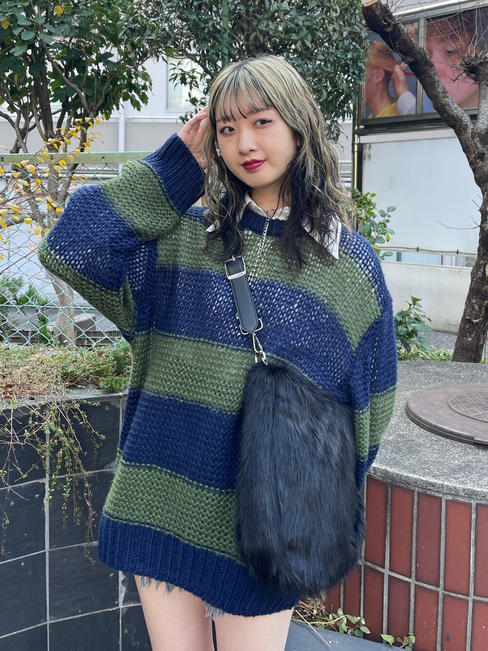 ブラック系のショルダーバッグ、ブラック系のブーツ、ブルー系のニット/セーターを着用したレディースの冬コーディネートの4枚目の写真