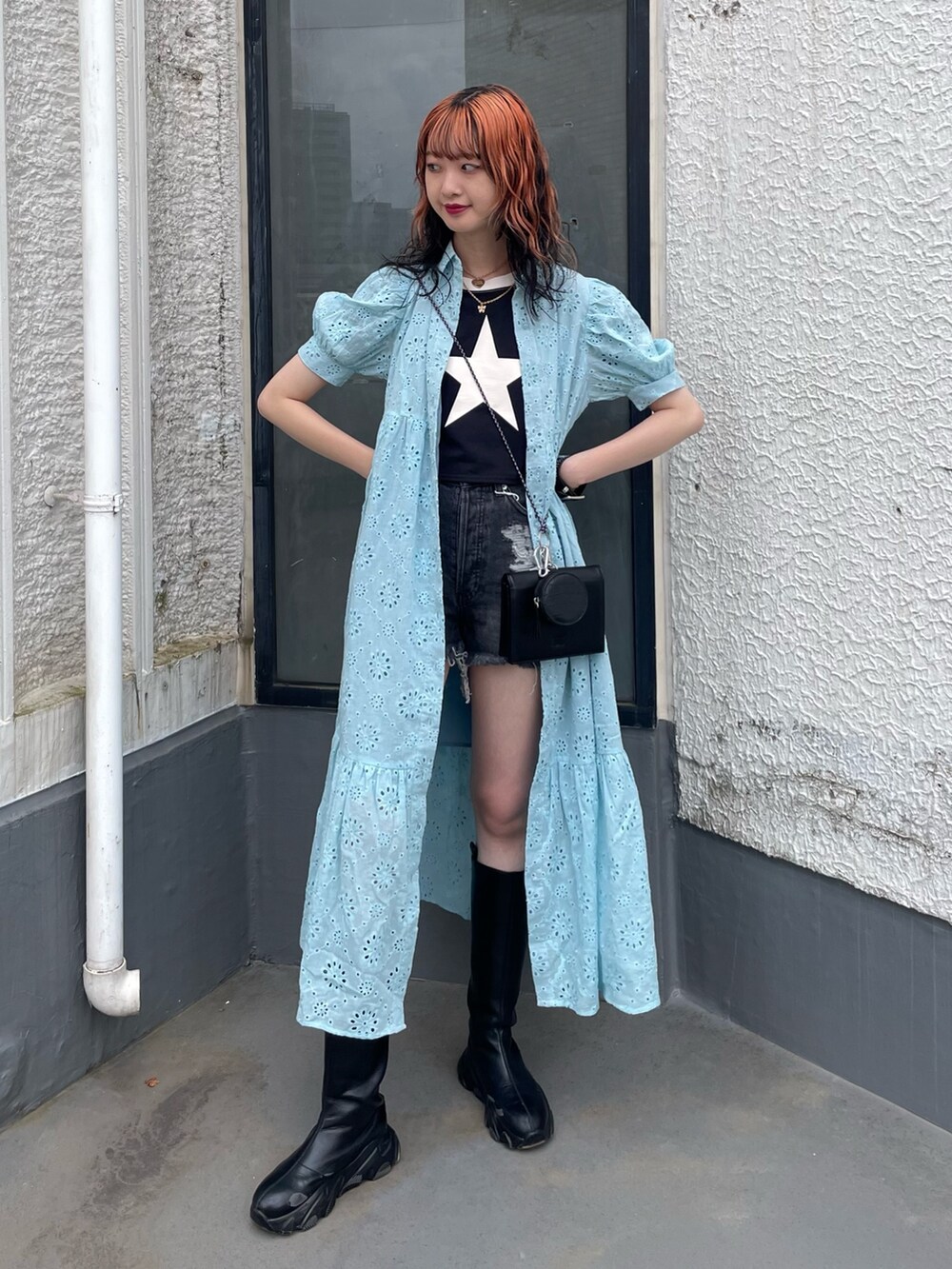 ブルー系のワンピース、ブラック系のショルダーバッグ、ブラック系のデニムパンツを着用したレディースの夏コーディネートの2枚目の写真