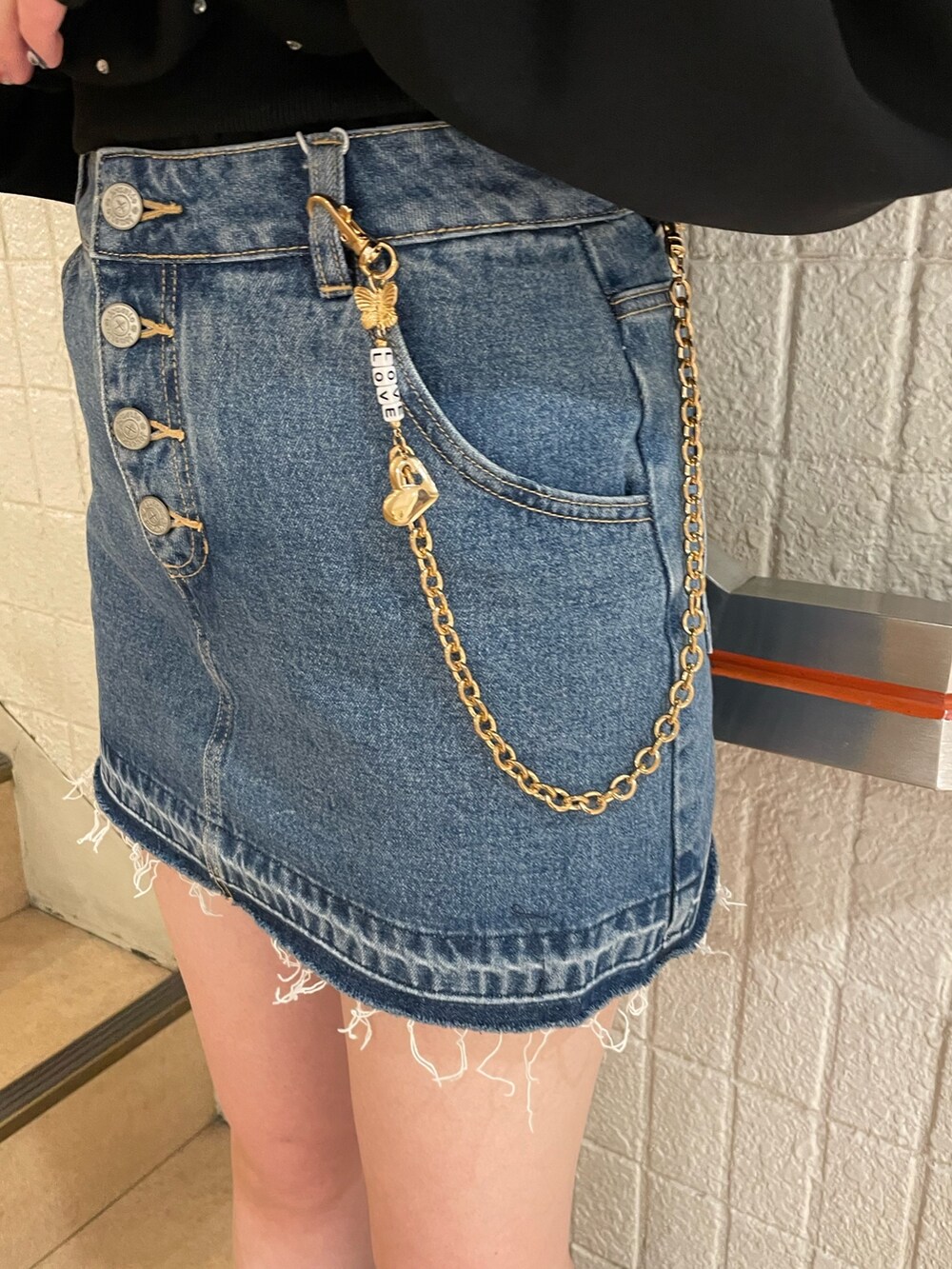 ブラック系のスウェット、ブルー系のデニムパンツ、ブラック系のブーツを着用したレディースの冬コーディネートの8枚目の写真