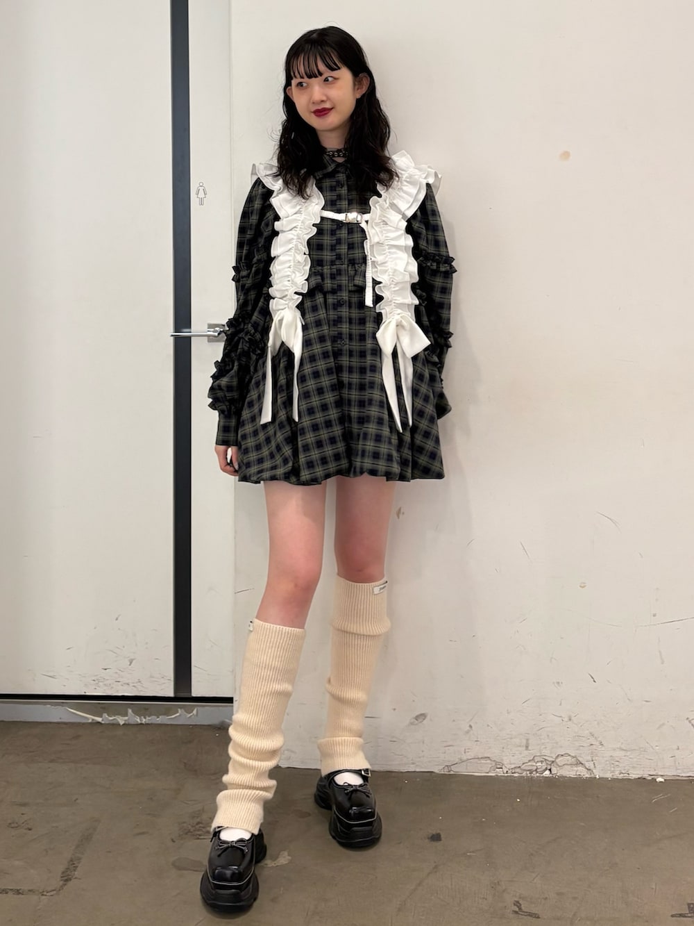 グリーン系のワンピース、ブラック系のスニーカー、ホワイト系のベルトを着用したレディースの夏コーディネートの2枚目の写真