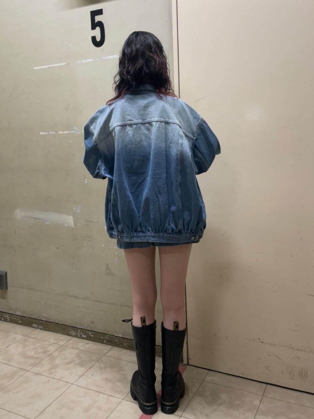 ブルー系のデニムジャケット、ホワイト系のTシャツ/カットソー、ブルー系のスカートを着用したレディースの春コーディネートの3枚目の写真