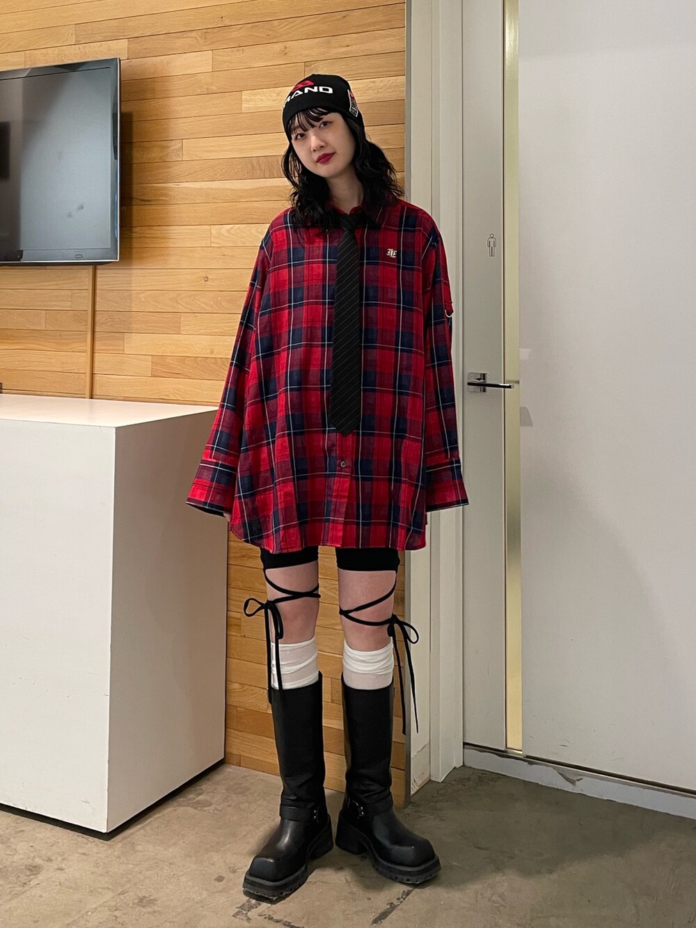 レッド系のシャツ/ブラウス、ブラック系のその他パンツ、ブラック系のブーツを着用したレディースの春コーディネートの2枚目の写真