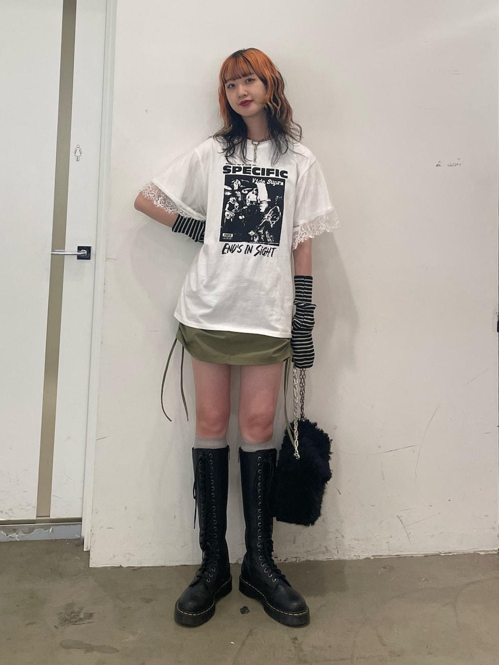ホワイト系のTシャツ/カットソー、ブラック系のハンドバッグ、ブラック系のブーツを着用したレディースの夏コーディネートの2枚目の写真
