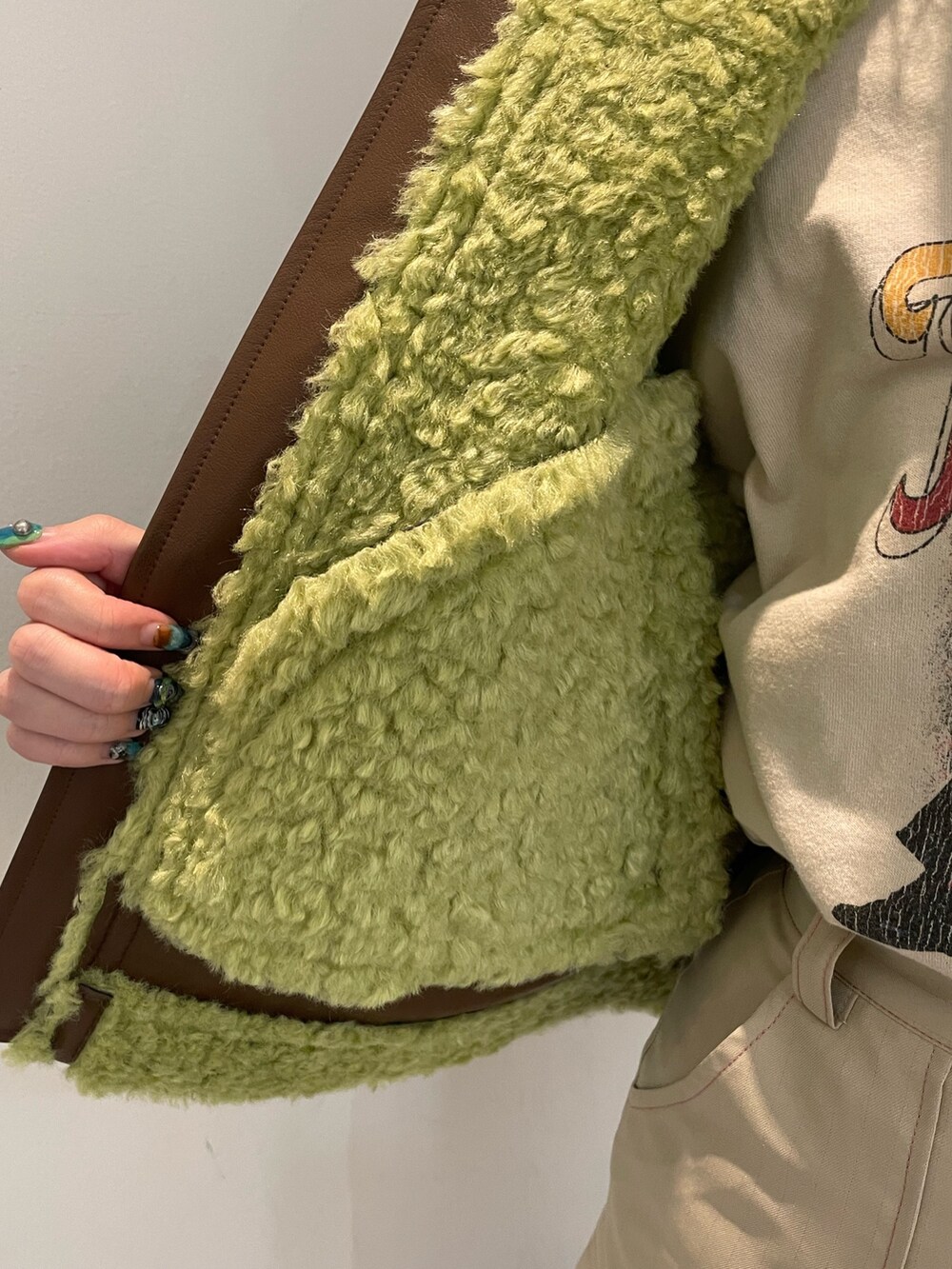 ブラウン系のその他アウター、ホワイト系のスカート、ブラック系のブーツを着用したレディースの冬コーディネートの6枚目の写真