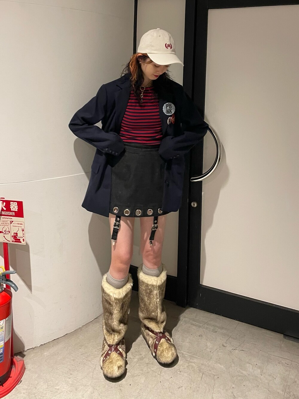 ベージュ系のブーツ、ブラック系のデニムパンツ、レッド系のTシャツ/カットソーを着用したレディースの夏コーディネートの2枚目の写真