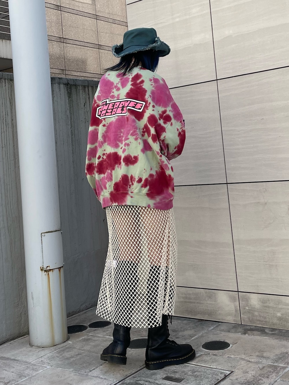 グリーン系のスウェット、ホワイト系のワンピース、ブラック系のブーツを着用したレディースの冬コーディネートの3枚目の写真