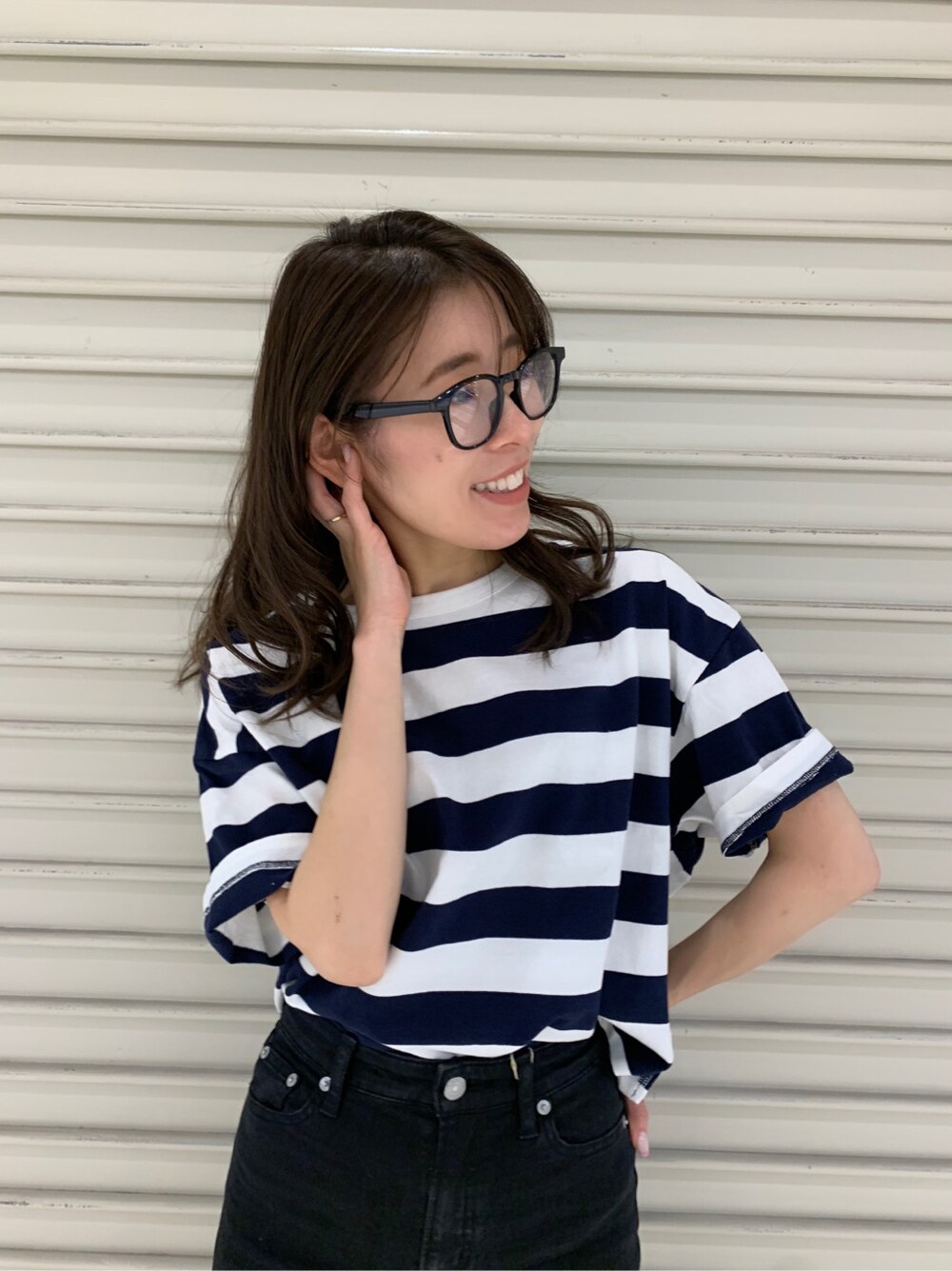 ブラック系のデニムパンツ、ブラック系のメガネを着用したレディースの春コーディネートの5枚目の写真