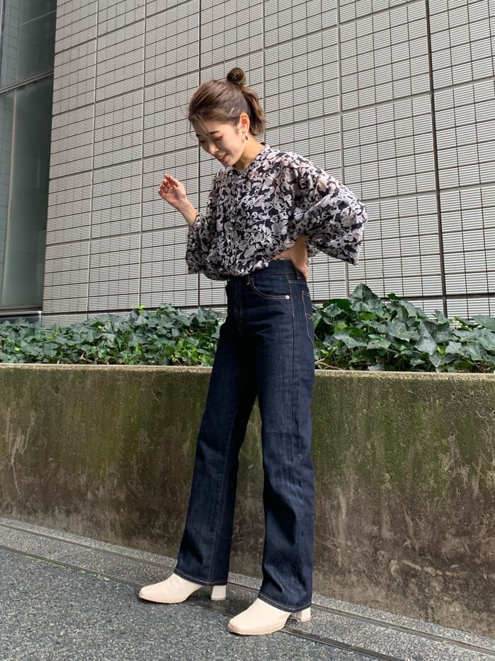 ブルー系のデニムパンツ、ブラウン系のトレンチコート、ブラック系のシャツ/ブラウスを着用したレディースの夏コーディネートの3枚目の写真