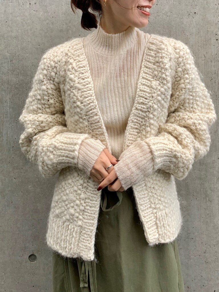 ホワイト系のニット/セーター、ホワイト系のカーディガン/ボレロ、ベージュ系のスカートを着用したレディースの秋コーディネートの3枚目の写真